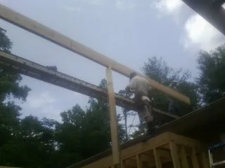 Carpenter setting a ridge beam over a new addition frame — Ice Dam Removal by Roofing Brothers in Tall Timbers