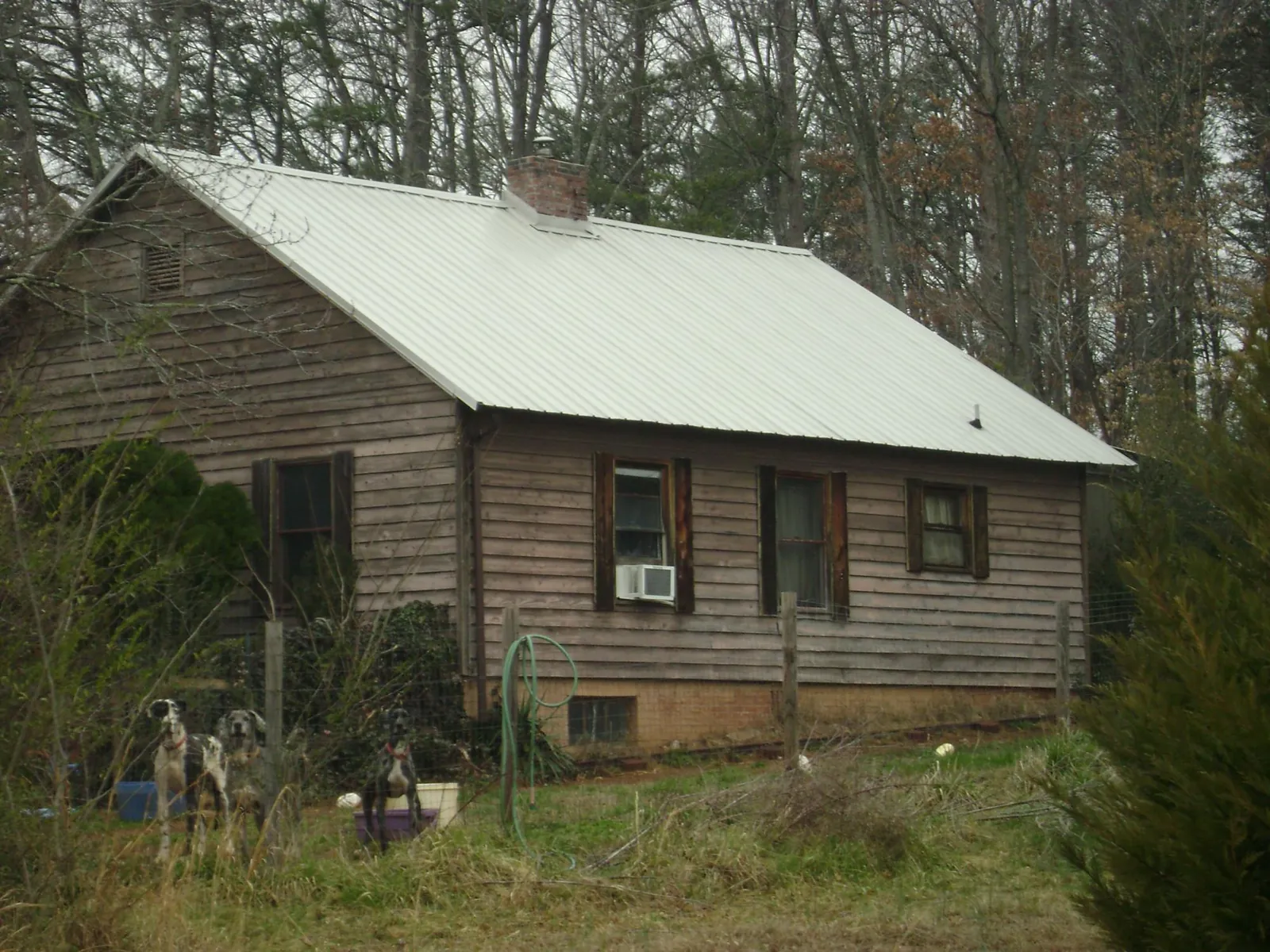 White metal roof on an old wood sided farmhouse, from a Metal Roof Installation job in Tall Timbers